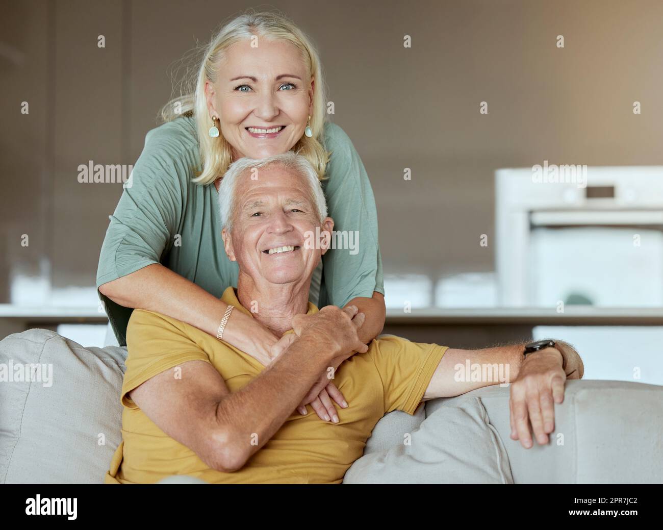 Coppia anziana felice che si lega e gode la pensione insieme. Uomo e donna caucasica anziana affettuosa su un divano a casa Foto Stock