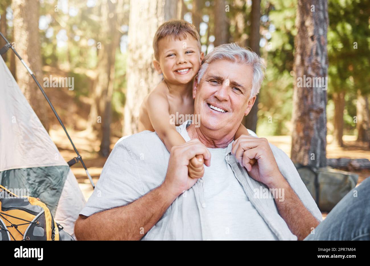 Ho pensato che Id lo prenda su una piccola avventura. Ritratto corto di un bel uomo maturo e suo nipote seduto al loro campeggio nel bosco. Foto Stock