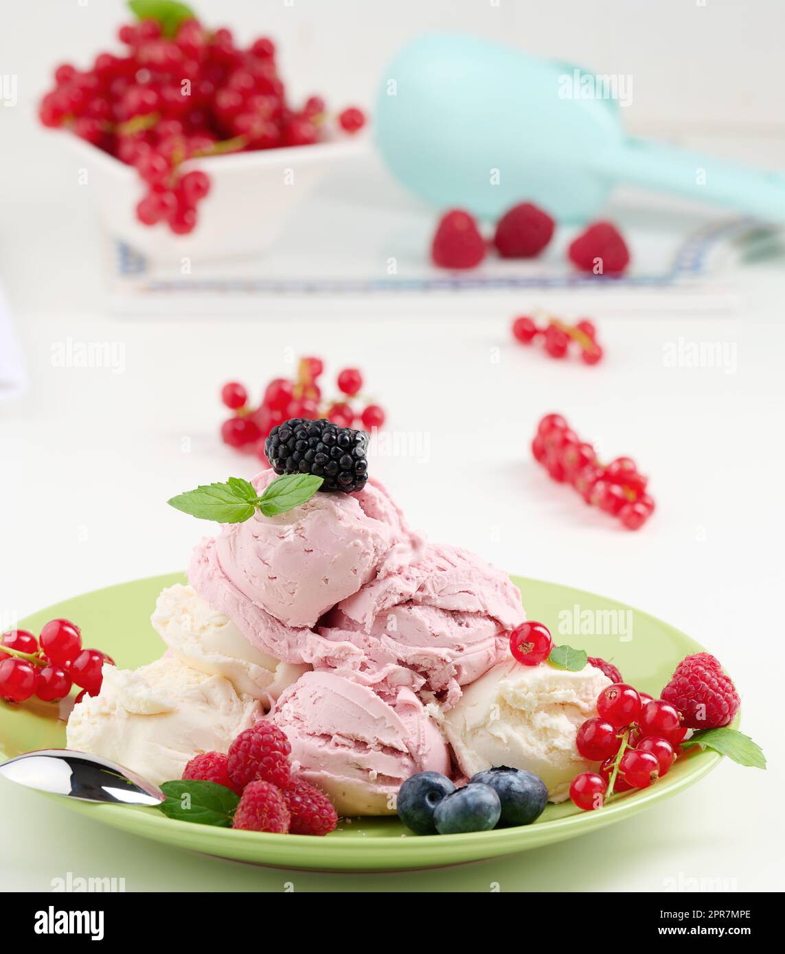 Misurini per gelato alla vaniglia e al lampone su un piatto rotondo verde Foto Stock