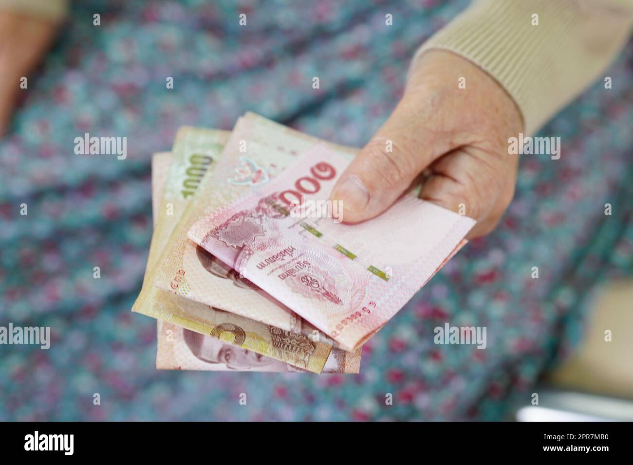 Donna anziana asiatica paziente con banconote in mano, costo della vita e assistenza medica. Foto Stock