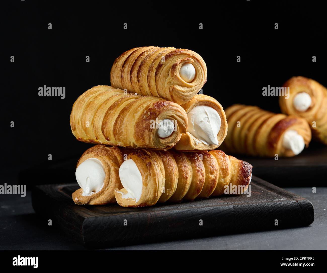 Tubuli al forno con crema proteica montata su un asse di legno Foto Stock