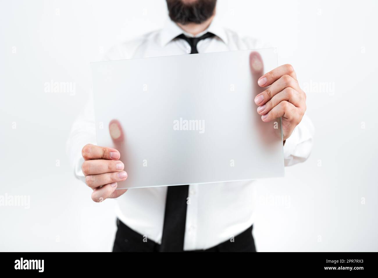 Uomo professionale che indossa la cravatta che tiene in mano un cartello vuoto e visualizza un messaggio importante. Uomo d'affari con la carta in mano che presenta strategie e informazioni per il progresso. Foto Stock
