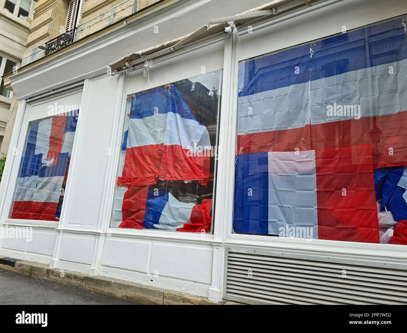 Bandiere francesi appese alle vetrine dei negozi Foto Stock