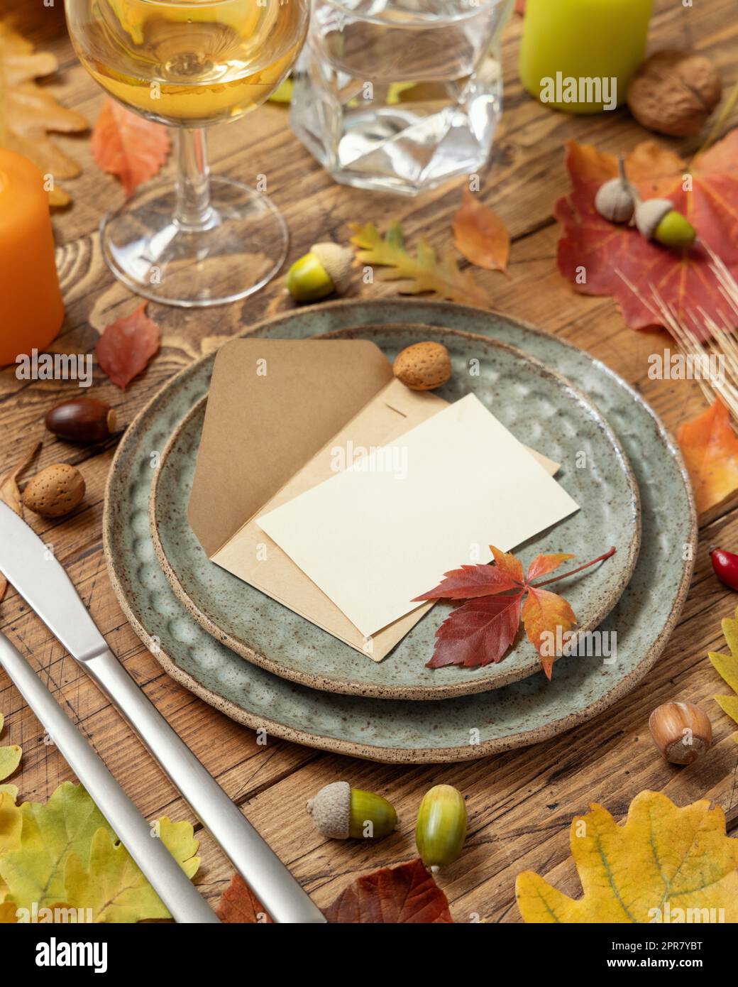 Tavolo autunnale con cartellino e busta tra foglie e frutti di bosco da vicino, mockup Foto Stock