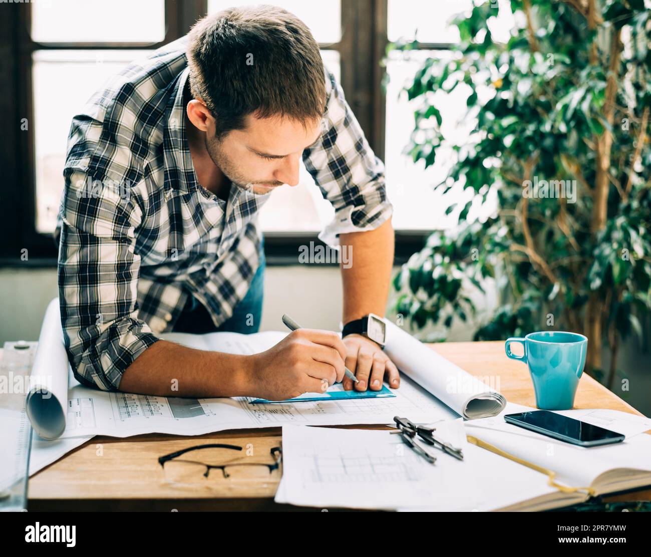 Uomo che lavora a un progetto architettonico Foto Stock