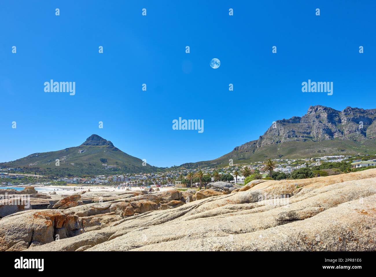 Paesaggio di montagne e luna su un cielo blu con spazio copia. Bellissimi affioramenti rocciosi sulle cime delle montagne vicino alla costa o alla zona della baia. Vista del Devils Peak e della Table Mountain a città del Capo, Sudafrica Foto Stock