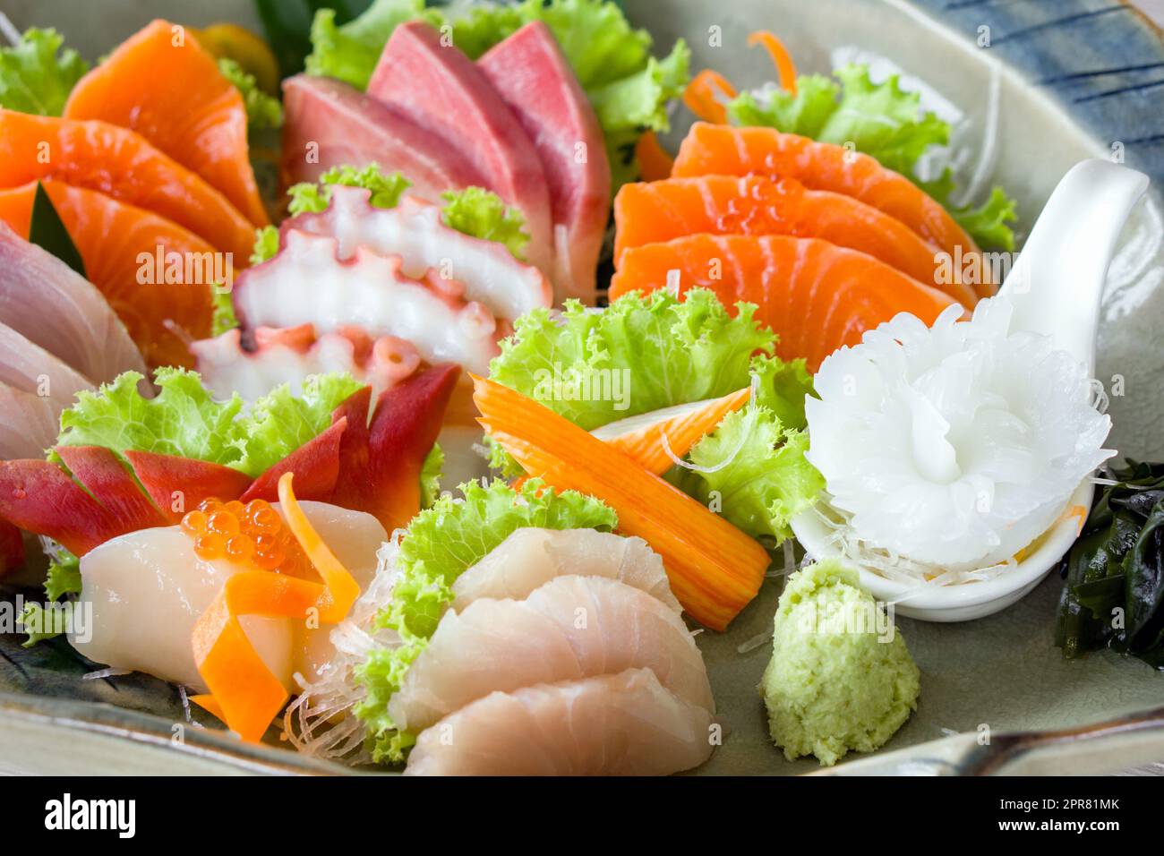 Sashimi mori, mix di sashimi serviti in un piatto di ceramica decorato con lattuga verde. Buffet di cucina giapponese. Scelta dello chef: Salmone, hamachi, Ika, Tako, Hotate e hokkigai Foto Stock