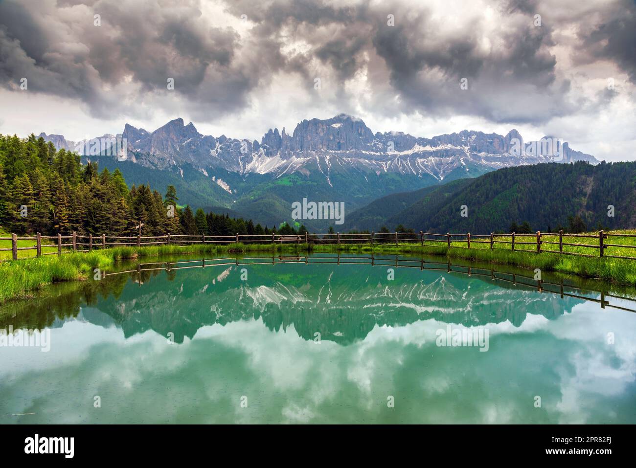 La catena montuosa del Rosengarten (Catinaccio) si riflette in un piccolo lago alpino, Tires, Trentino-Alto Adige/Sudtirolo, Italia Foto Stock