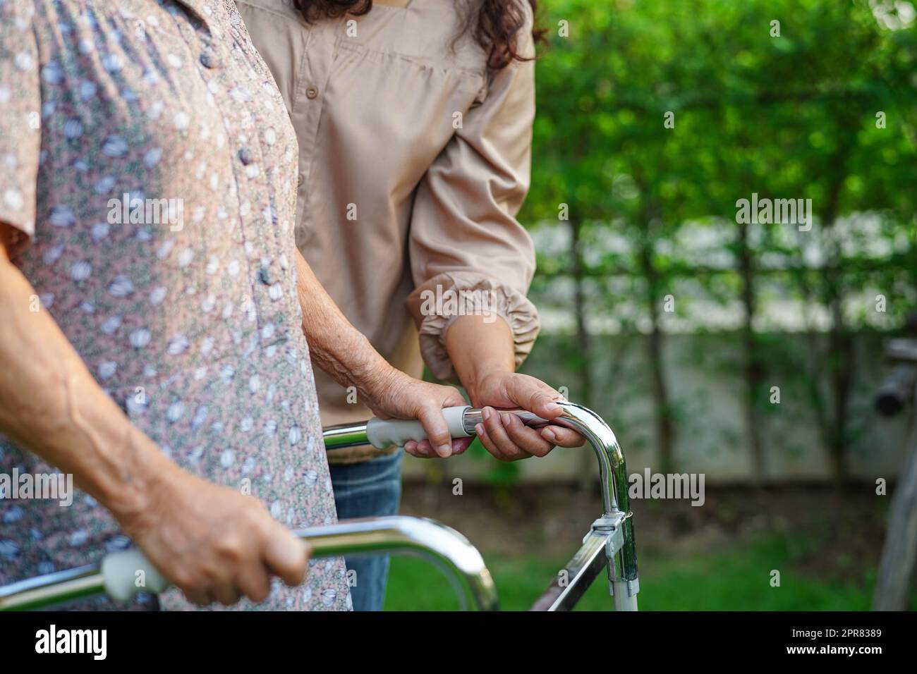 L'assistente aiuta il paziente asiatico anziano di disabilità della donna in ospedale di cura, concetto medico. Foto Stock