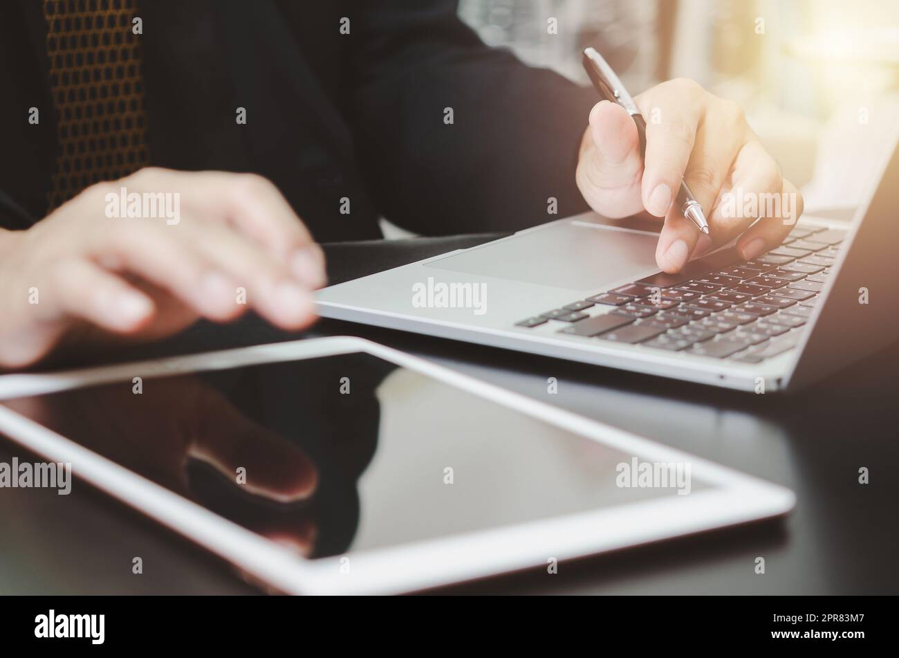 Uomo d'affari che tiene una tastiera per digitazione, un computer, un notebook e un tablet sulla scrivania. Tecnologia aziendale Internet digitale lavoro ricerca di lavoro e concetto di comunicazione. Foto Stock