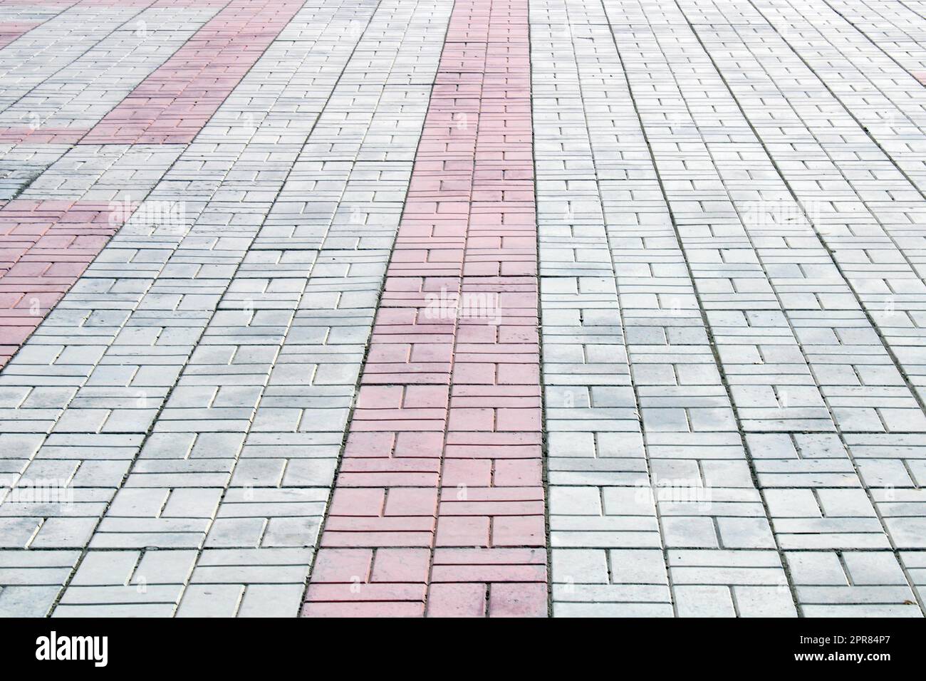 Piastrelle bianche, grigie e rosse sul marciapiede. Architettura, costruzione. Sfondo riccio astratto. Foto Stock
