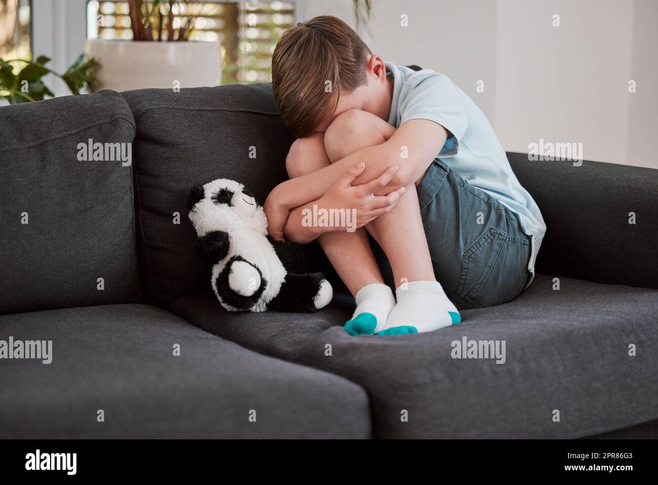 Un giocattolo morbido è Dio per un bambino infelice. Scatto di un ragazzino che si confortava su un divano a casa. Foto Stock
