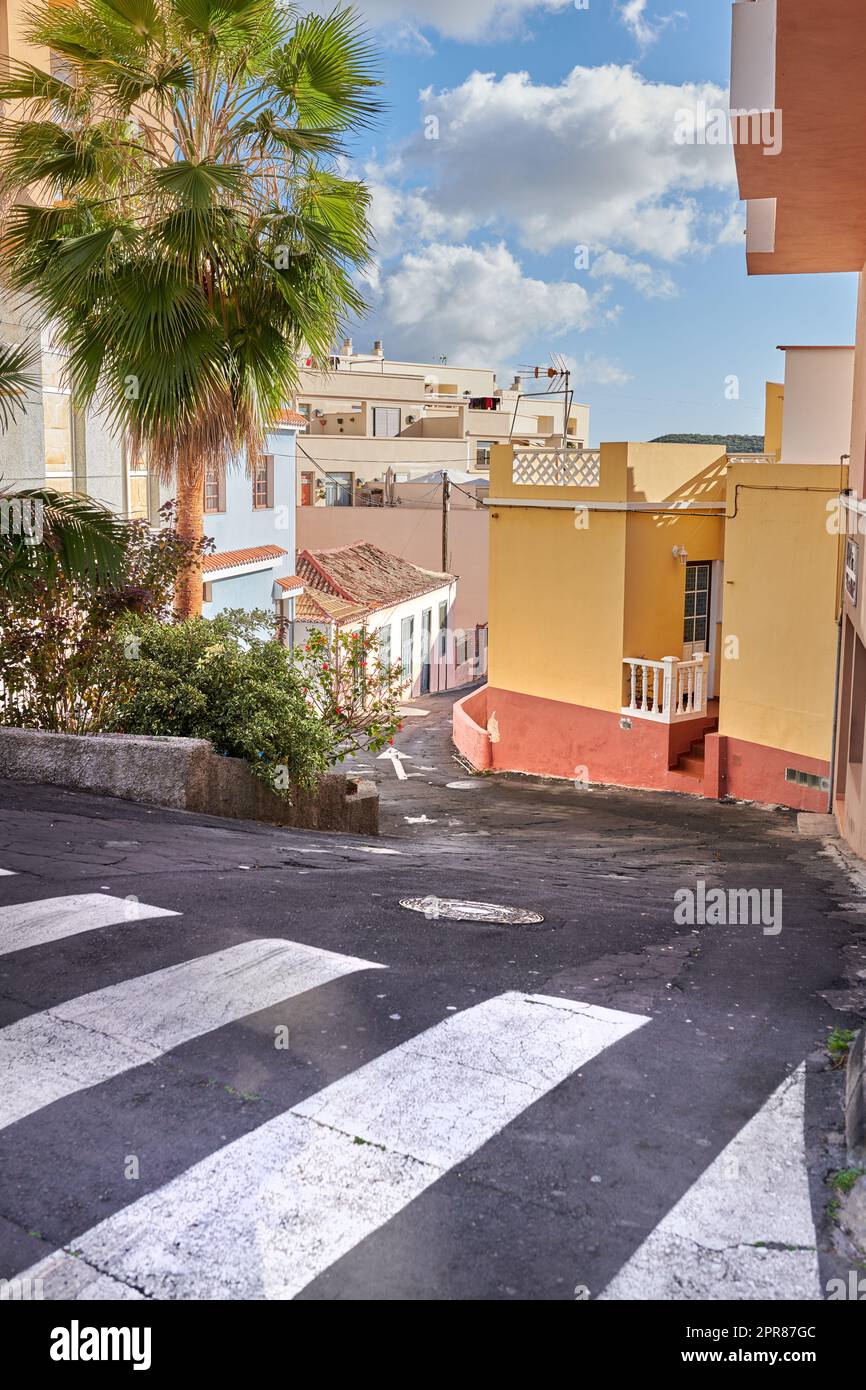 Una strada tortuosa con architettura tradizionale a Santa Cruz de la Palma. Strada tranquilla e vuota in una piccola città turistica europea. Un vicolo stretto in una città rurale con edifici e case colorate. Foto Stock