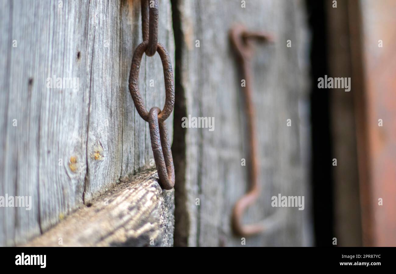 Isolato vecchio fermo della porta arrugginito su una porta di legno. Primo piano. Pannelli con agenti atmosferici problematici. Vecchio sfondo a struttura di parete. Particolare di una vecchia porta in legno con Foto Stock