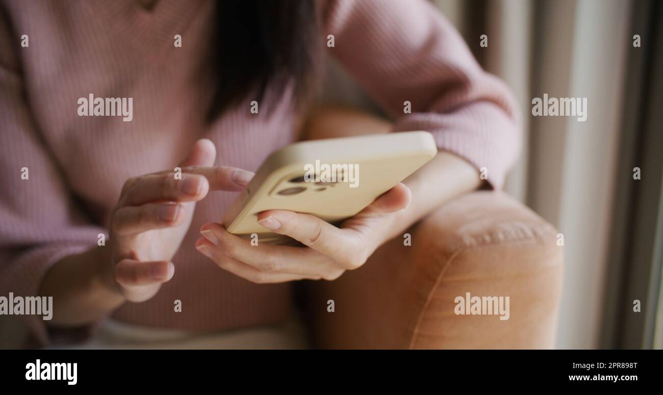 Donna uso del telefono cellulare a casa Foto Stock