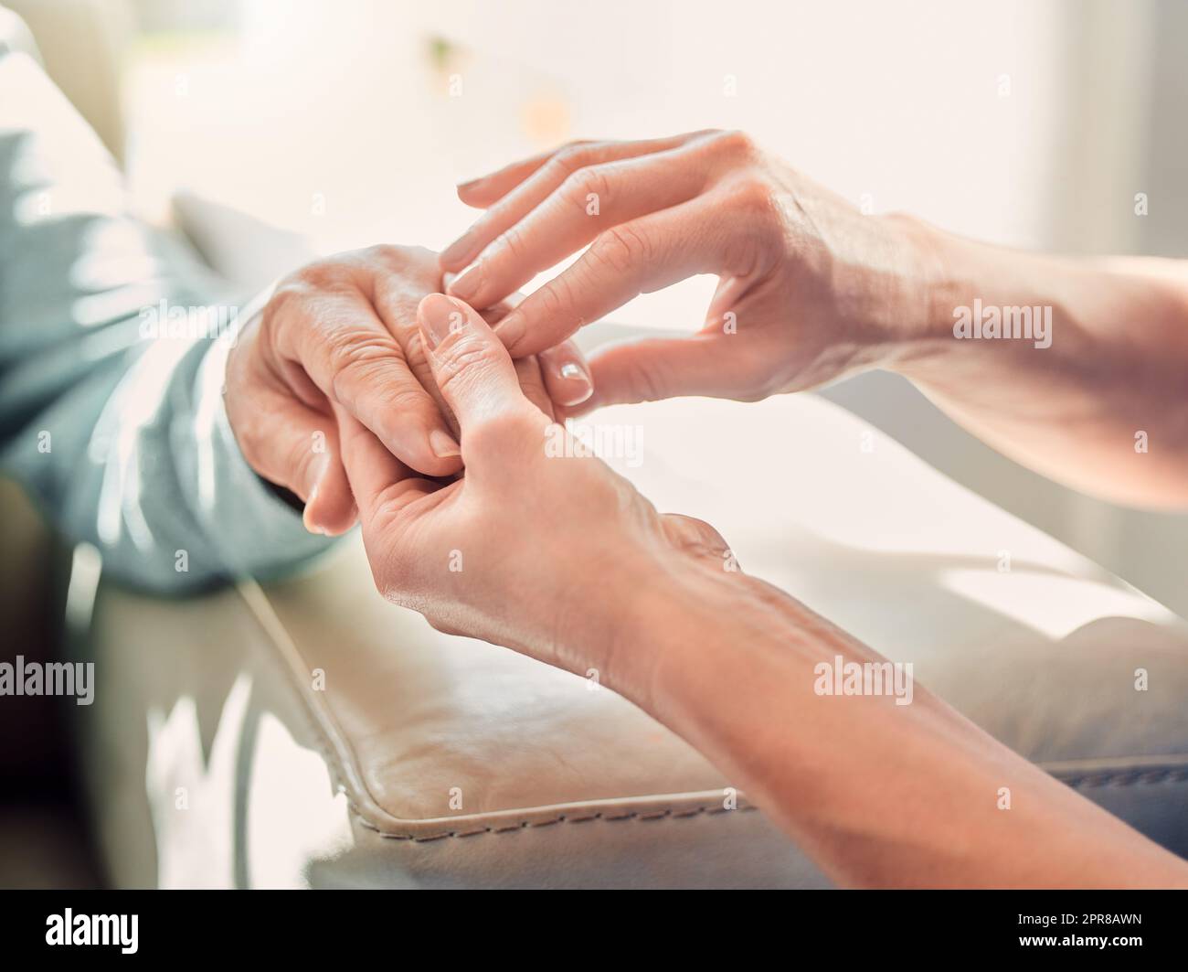 Solo dando è in grado di ricevere di più. Colpo di un'infermiera irriconoscibile che massaggiano una mano femminile a casa. Foto Stock