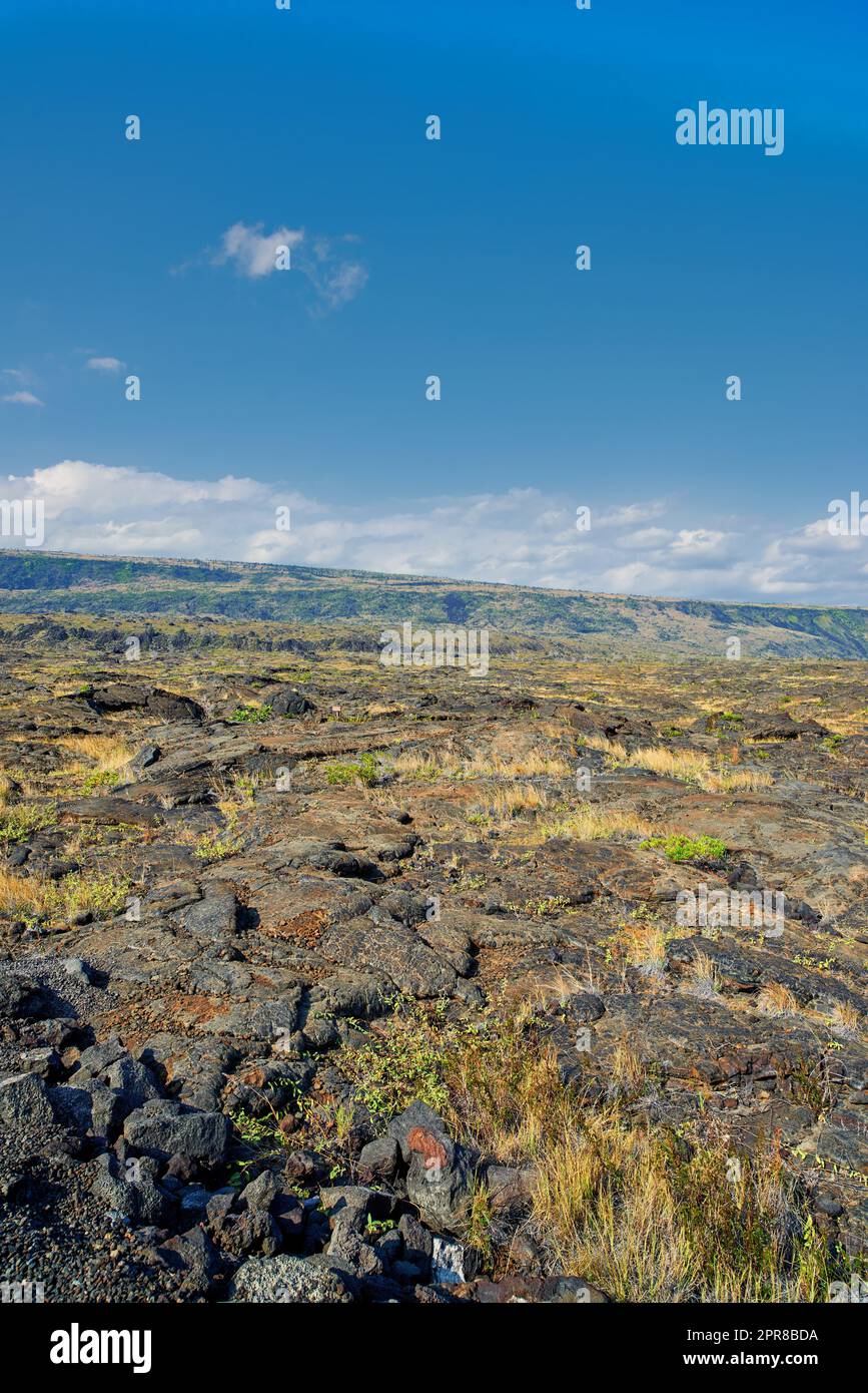 Vista panoramica della grande Isola delle Hawaii con spazio per la copia. Vista panoramica del vulcano dormiente Mauna Kea con copyspace. Vasta distesa di lava fresca che scorre in natura e cielo blu vicino a una cima di terra vulcanica Foto Stock