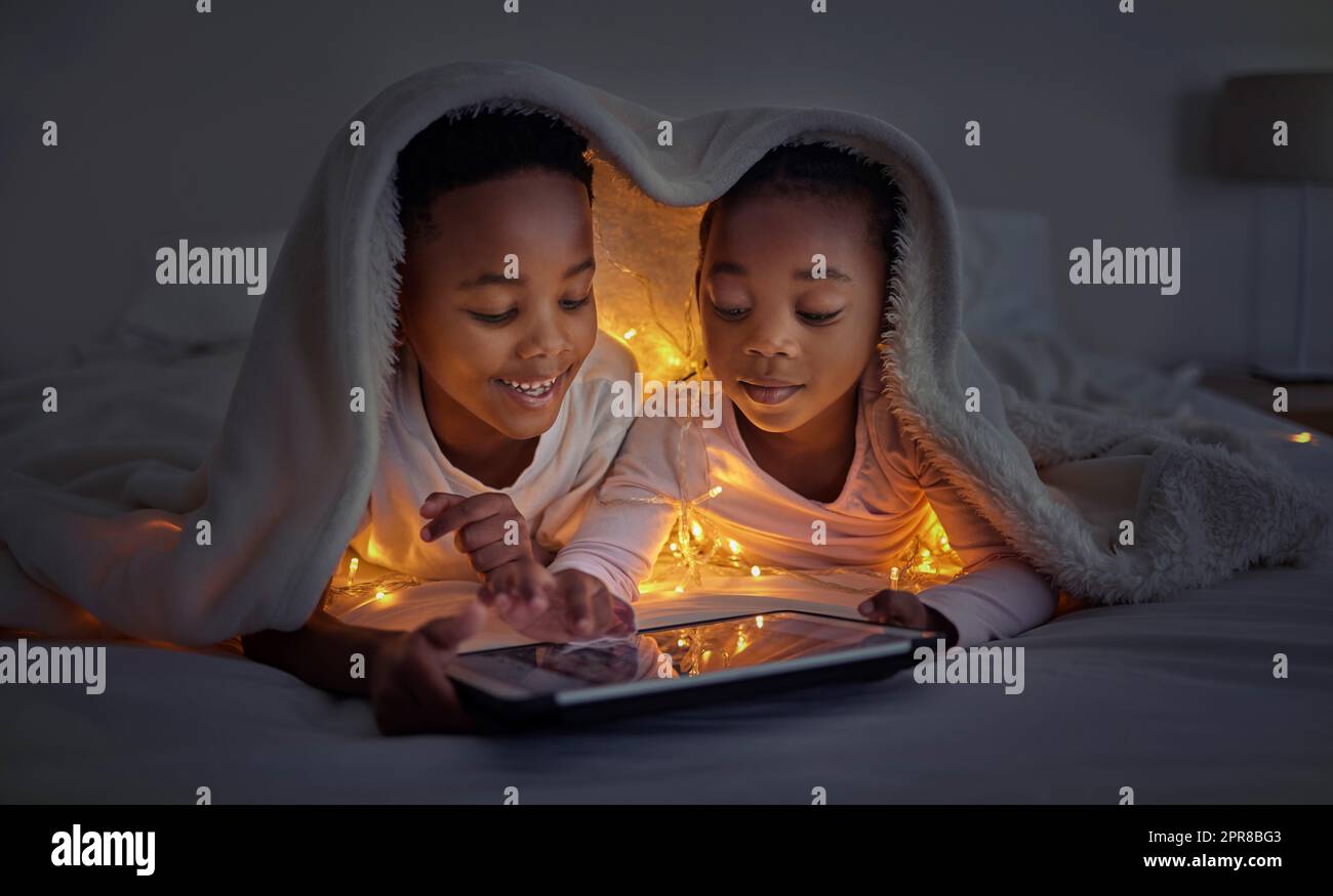 io e ou siamo fratelli e sorelle per sempre, un fratello e una sorella che usano una tavoletta a letto di notte. Foto Stock