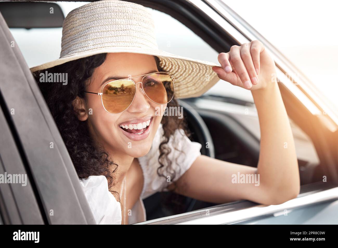 L'estate è qui, lasciate che la roadtripping abbia inizio. Una bella giovane donna che si appoggia al finestrino della macchina. Foto Stock