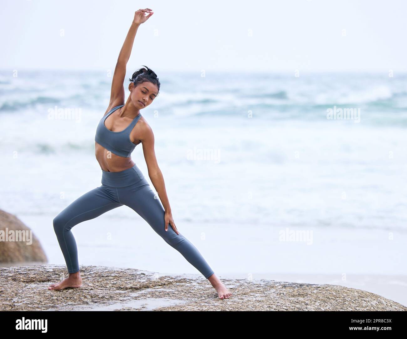 Lo yoga è uno stile di vita. Scatto a tutta lunghezza di una giovane donna che pratica yoga sulla spiaggia. Foto Stock