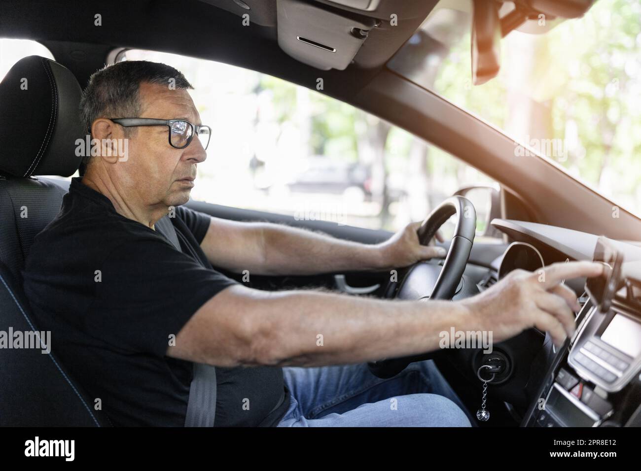 Senior dietro il volante utilizzando la navigazione gps Foto Stock