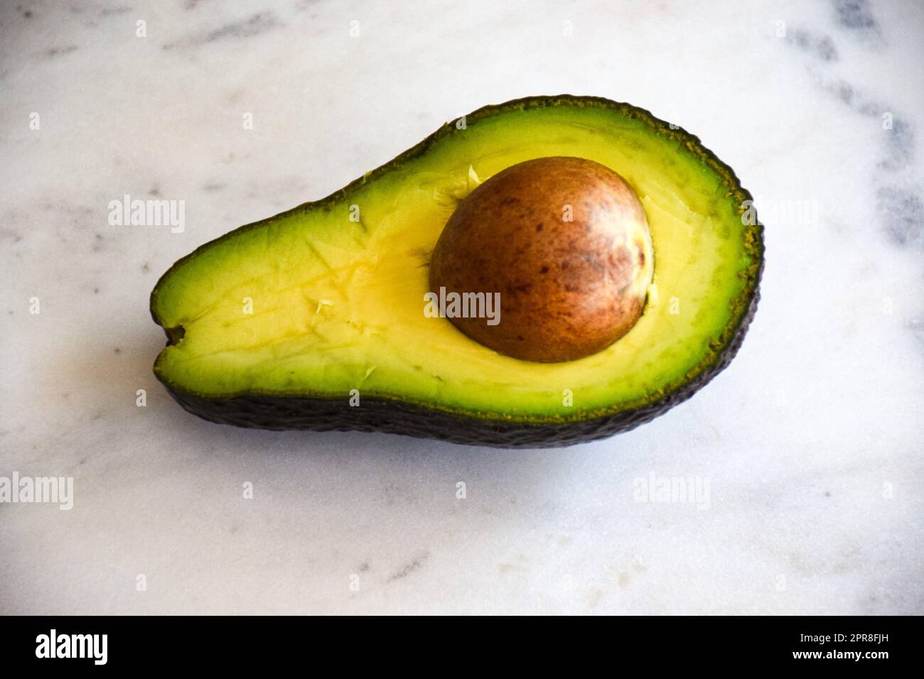 Avocado metà su sfondo bianco, metà avocado Foto Stock