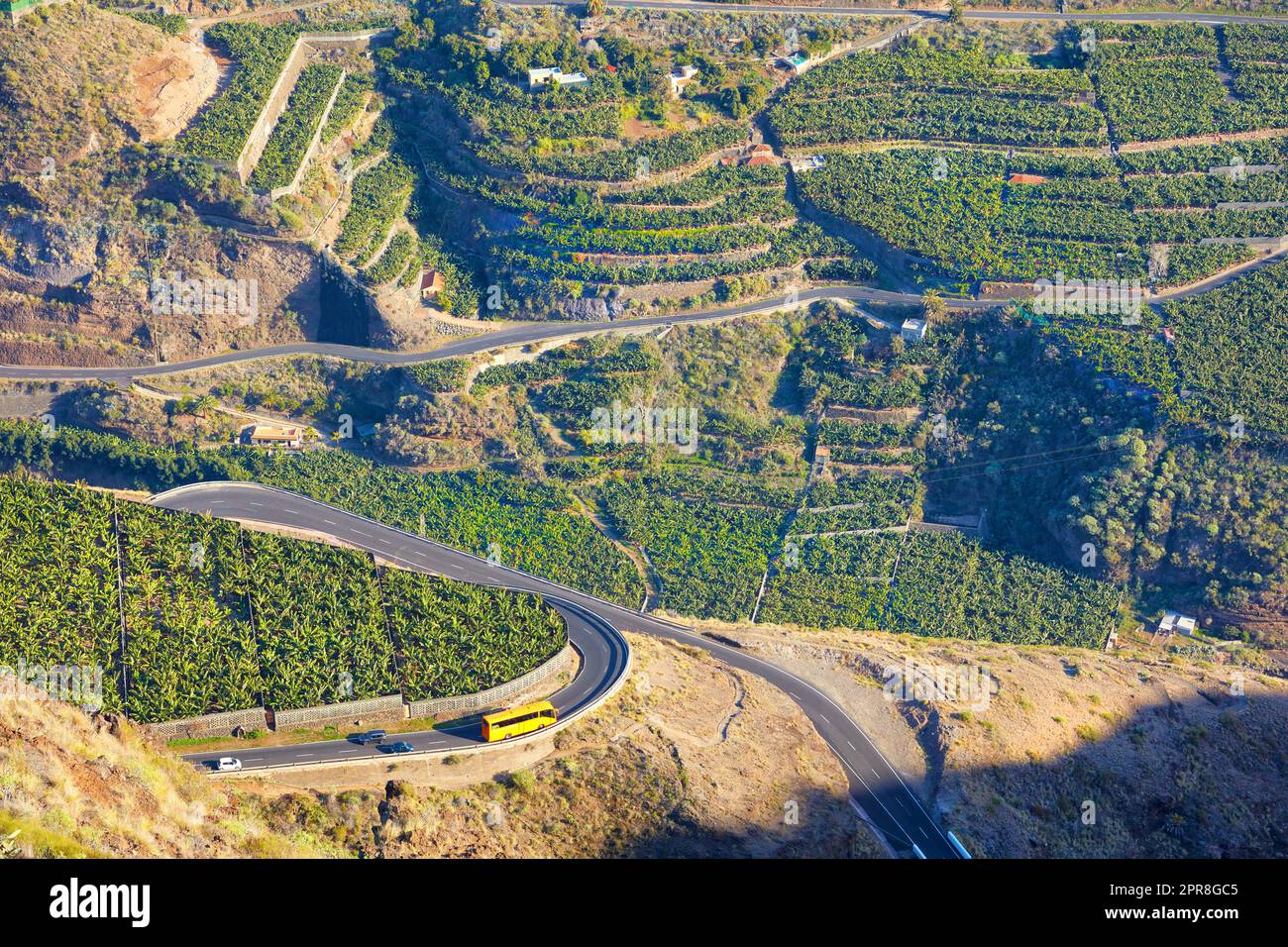 Splendido paesaggio di un piccolo villaggio agricolo in un pomeriggio di sole vicino a un'autostrada o a una strada trafficata per la logistica o il trasporto di merci. Piantagioni di banane nella città di Los Llanos, la Palma, Spagna Foto Stock