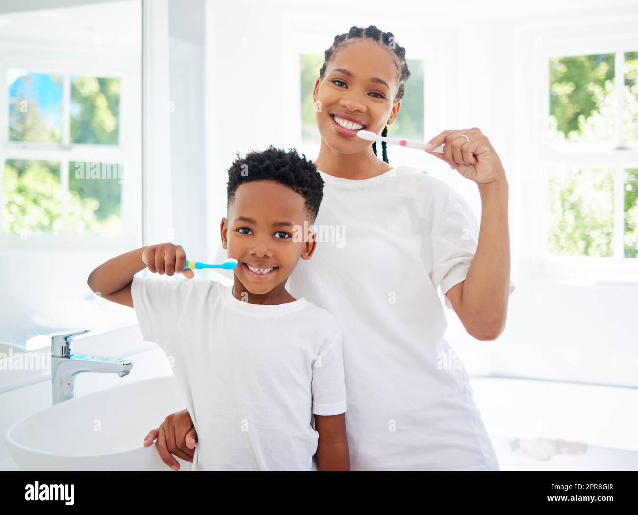 Prendersi cura di denti e gengive è fondamentale per la salute a lungo termine. Ritratto del bambino e della madre che si lavano i denti insieme in un bagno a casa. Foto Stock