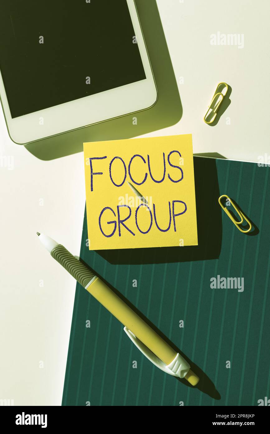 Segno di scrittura a mano Focus Group. Word Written on Show assemblato per partecipare alla discussione su qualcosa Nota con messaggio importante sulla scrivania con penna, telefono cellulare e graffette. Foto Stock