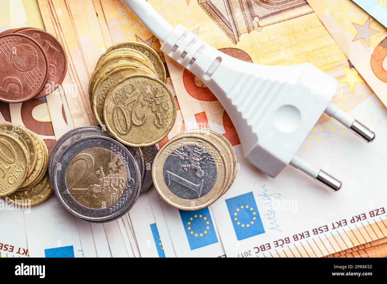 Concetto di risparmio energetico con spina di alimentazione e denaro in euro Foto Stock