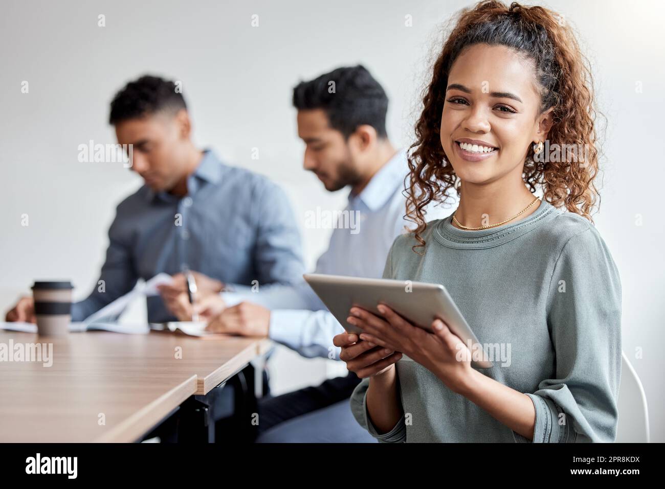 Ho trovato un qualcosa che semplifica le nostre sessioni di brainstorming. Scatto di una donna d'affari che tiene un tablet digitale mentre è in piedi nella sala riunioni. Foto Stock