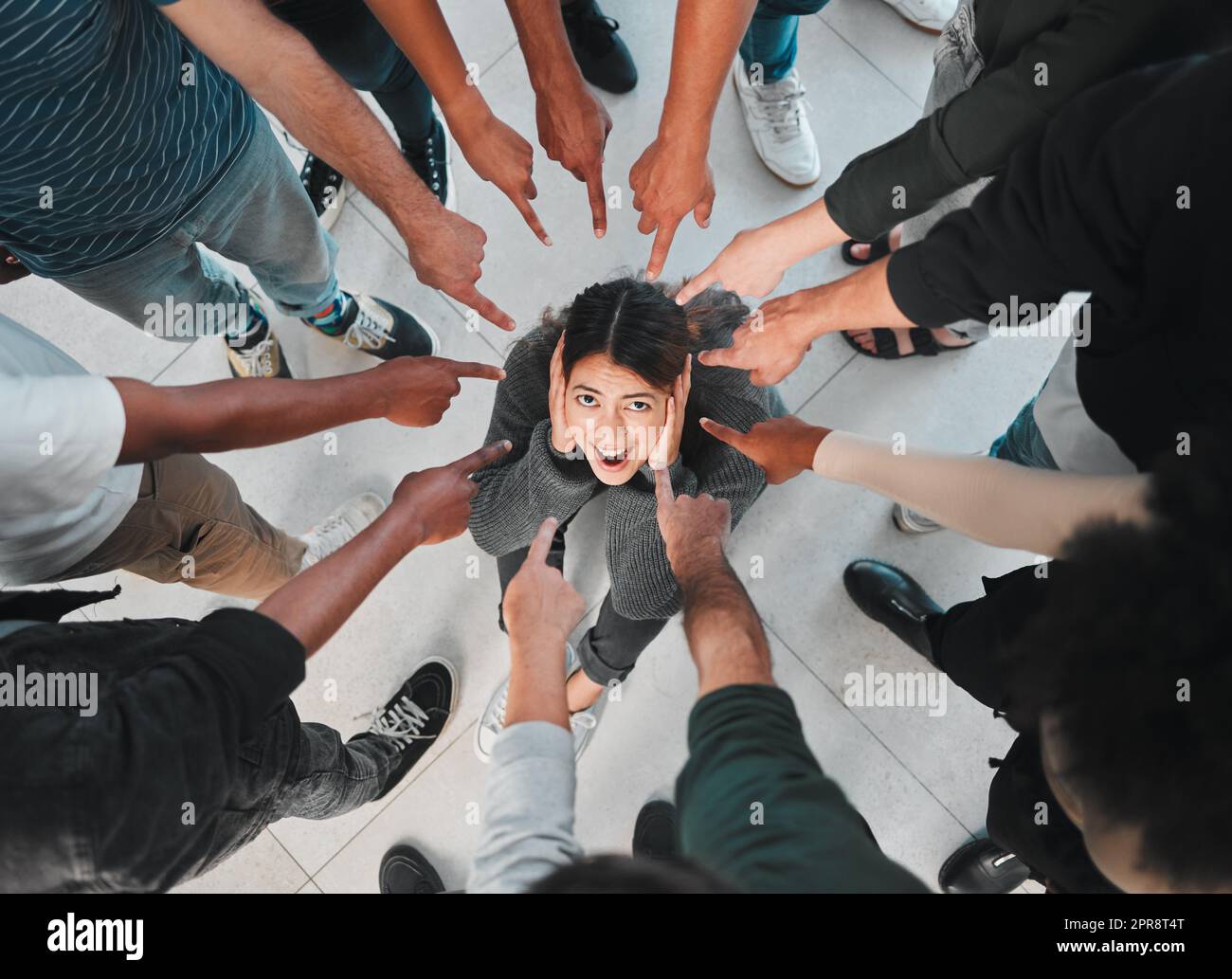 Non riesco a descrivere il mio modo di sentire: Una giovane donna che vive una malattia mentale mentre è circondata da persone all'interno. Foto Stock