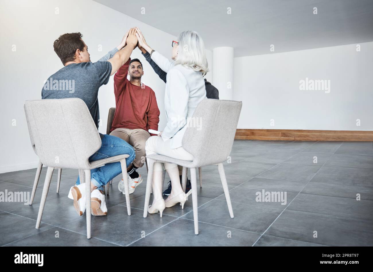 Gruppi diversi di uomini d'affari che si regalano cinque persone sedute in una riunione in un ufficio al lavoro. Donne e uomini felici che si uniscono per motivare mentre lavorano insieme Foto Stock