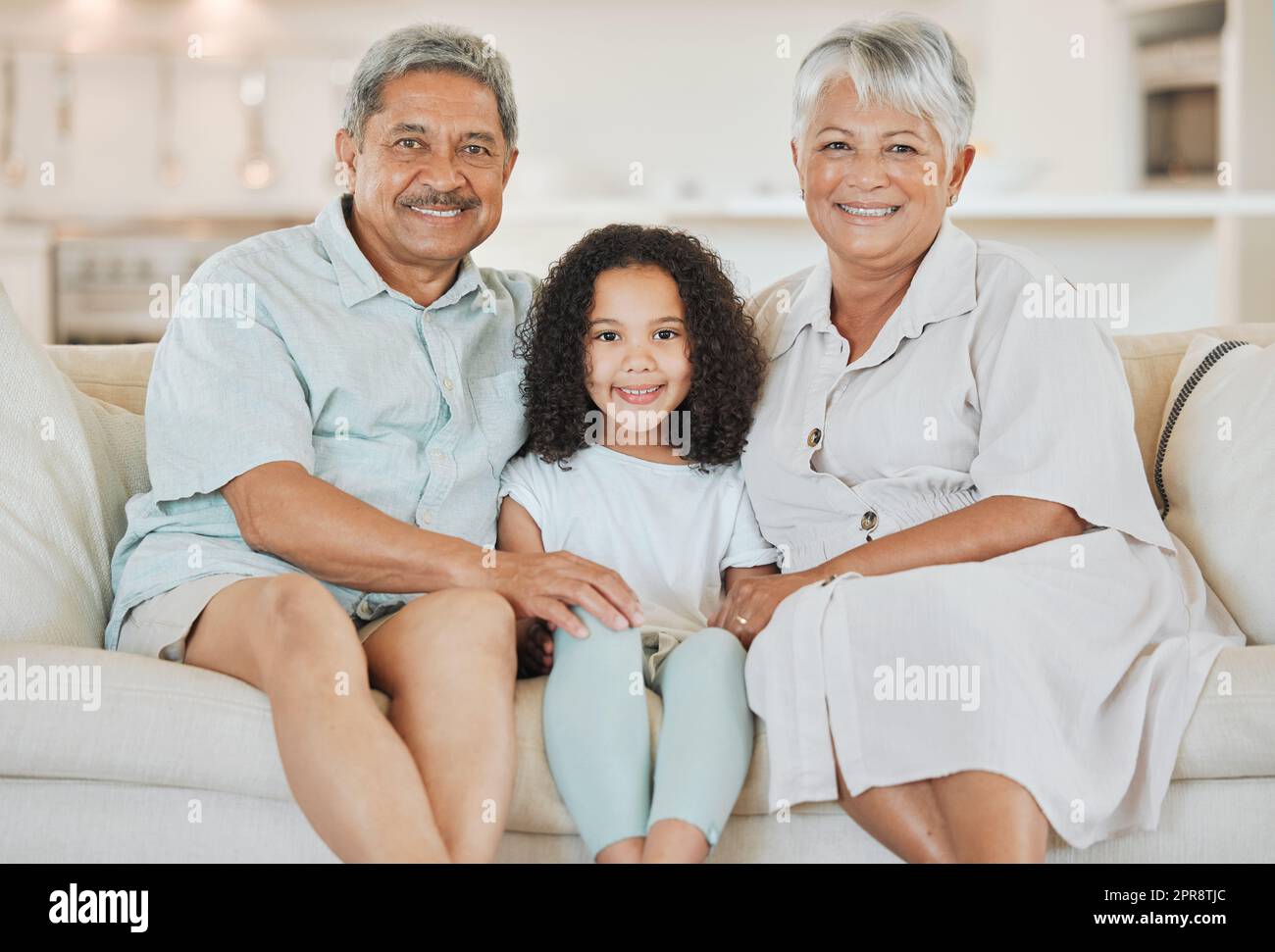 I nonni che si legano con il loro nipote su un divano a casa. Foto Stock