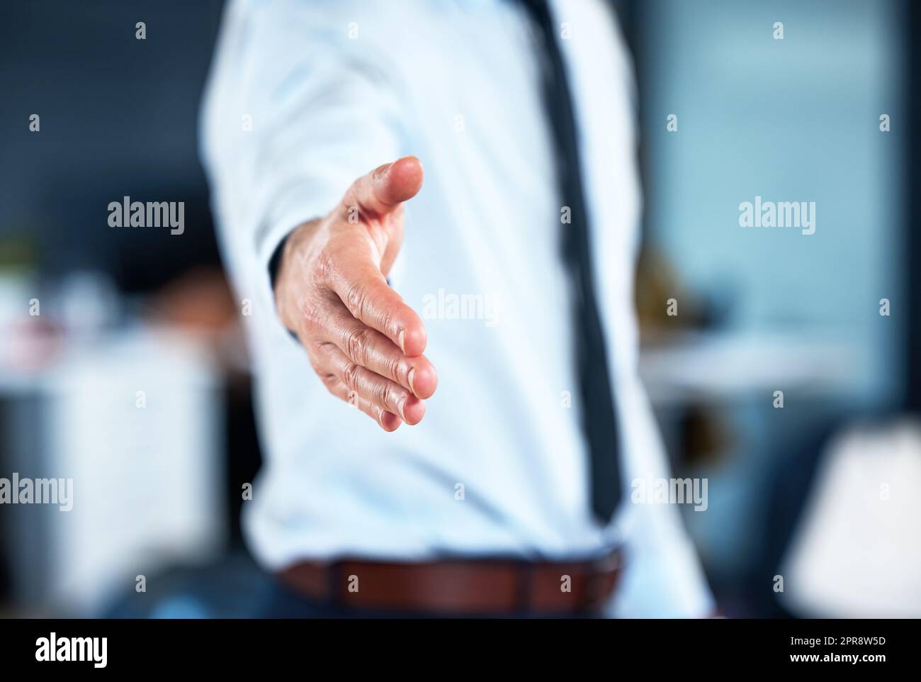 Benvenuti in azienda. Un imprenditore incognibile che si estende la mano per una stretta di mano. Foto Stock