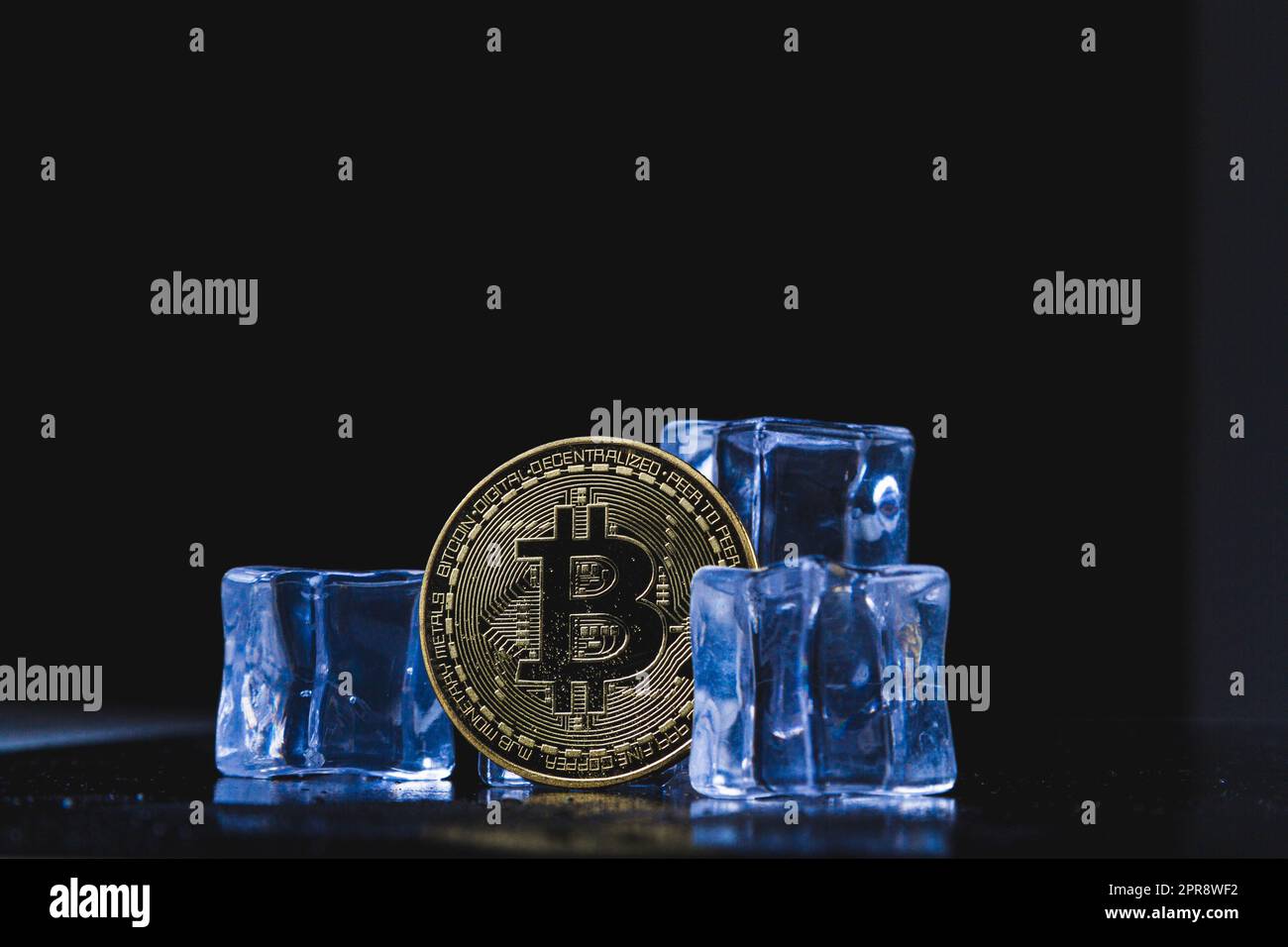 Moneta di ghiaccio e bitcoin. Congelamento dei conti di criptovaluta. Moneta bitcoin congelata.. Foto Stock