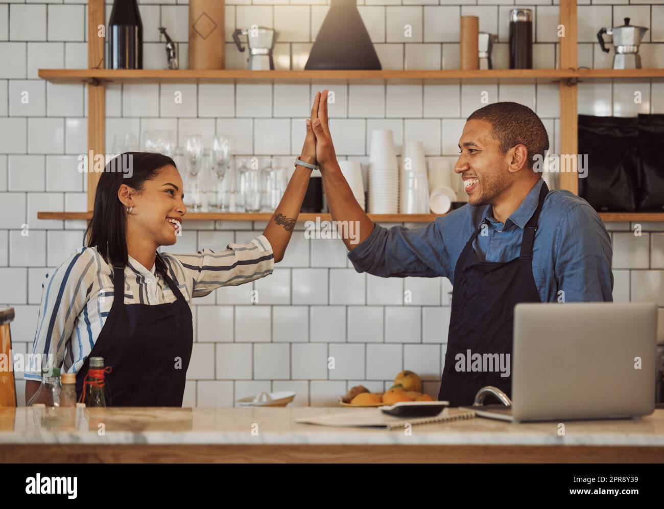 I partner commerciali fanno cinque a vicenda. I colleghi felici si motivano a vicenda in un negozio. I proprietari dei ristoranti collaborano e festeggiano insieme. Gli imprenditori celebrano il successo del loro coffee shop Foto Stock