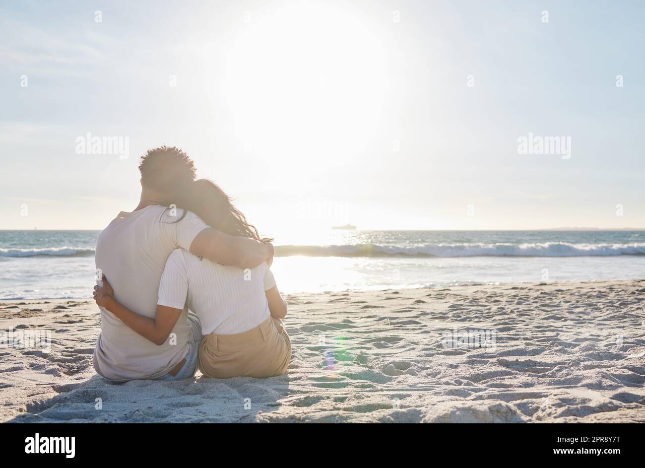 Fare il tempo per quei momenti speciali. Scatto completo di una giovane coppia affettuosa che condivide un momento intimo in spiaggia. Foto Stock