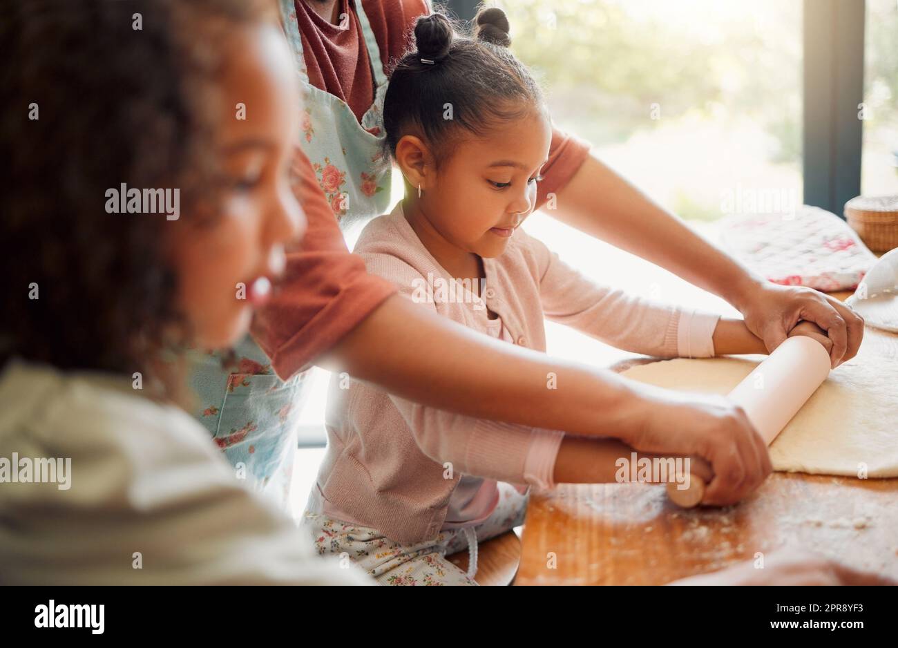 Solo femmine, felice famiglia mista di tre persone che cucinano insieme in una cucina disordinata. Amava i genitori single neri che legavano con le sue figlie mentre insegnavano loro le abilità domestiche a casa Foto Stock