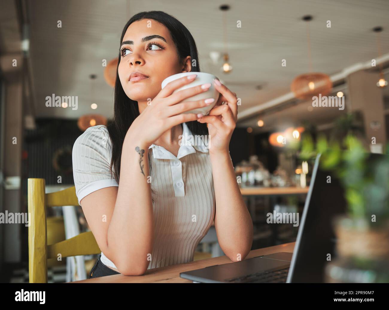 Ha grandi sogni, una giovane donna d'affari che si fa una pausa dal lavoro per gustare il caffè in un bar. Foto Stock