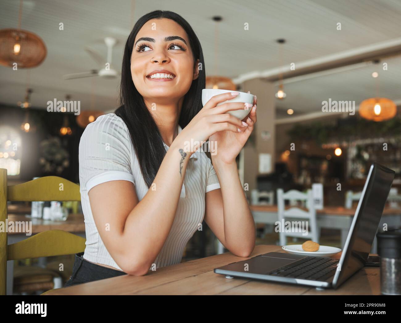 Lavorare per una vita di cui può essere orgogliosa. Una giovane donna d'affari che si prende una pausa dal lavoro per gustare il caffè in un caffè. Foto Stock