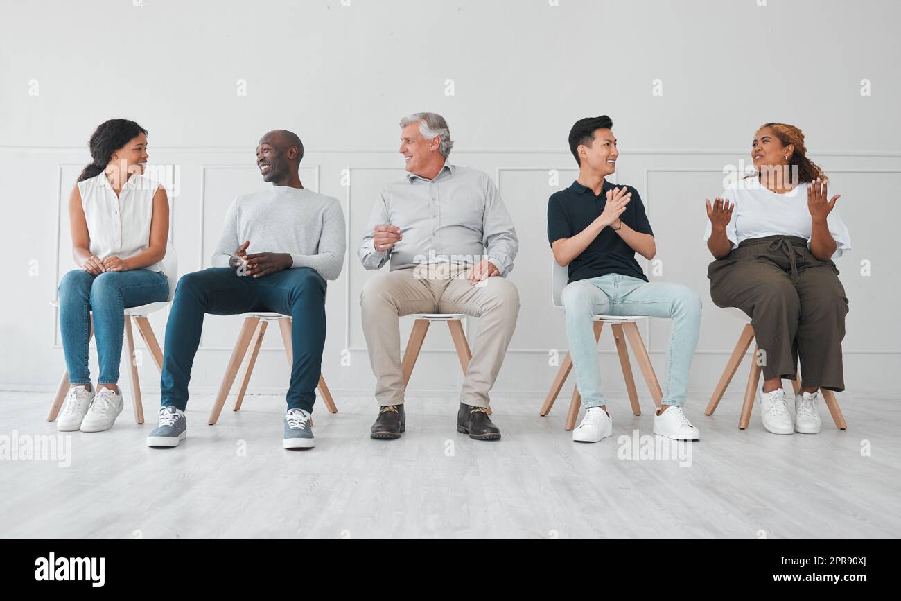 Parlando di tutti gli argomenti più caldi attuali, un gruppo di persone diverse che parlano tra loro mentre si siedono in fila su uno sfondo bianco. Foto Stock