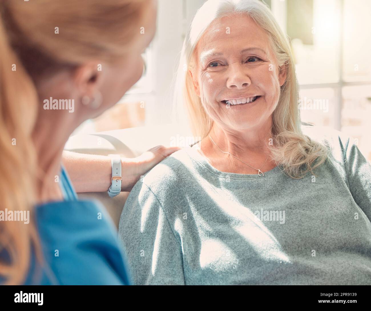 C'è più felicità nel dare che nel ricevere: Una donna anziana è sostenuta dalla sua infermiera a casa. Foto Stock