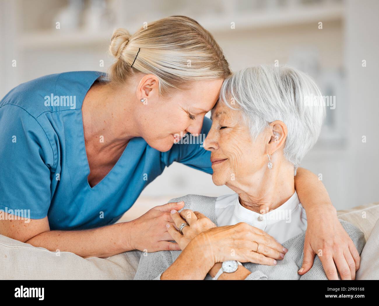 Capisco, e mi qui per voi. Un'infermiera che si prende cura di una donna anziana a casa. Foto Stock