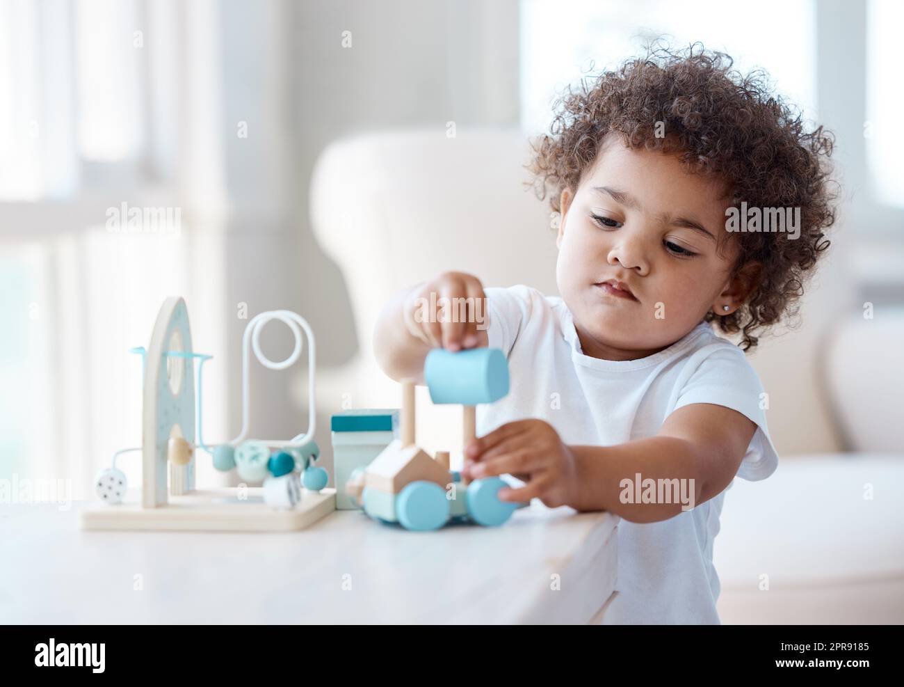 Una bambina che gioca con un giocattolo a casa. Foto Stock