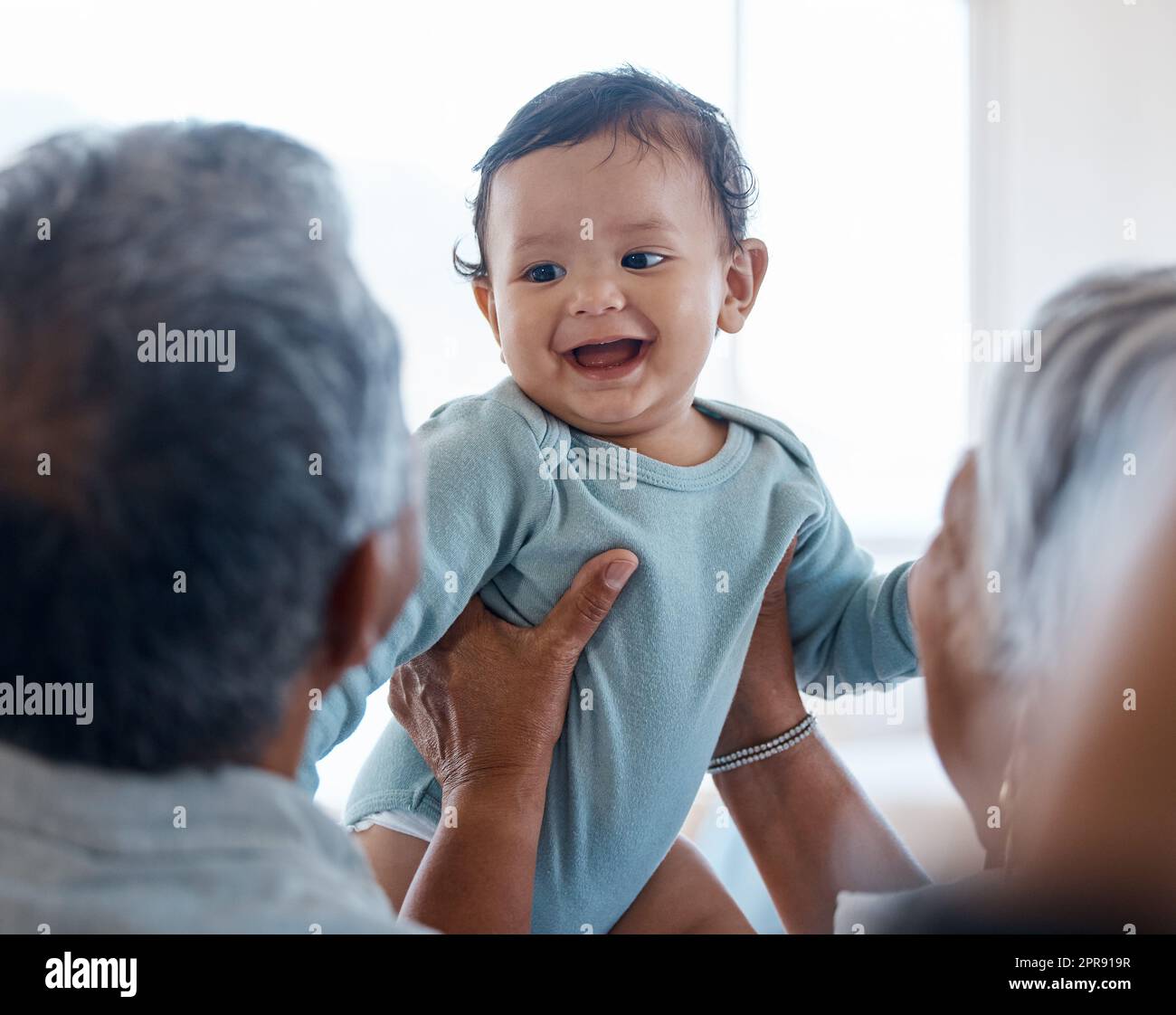 Appeso sul respiro del bambino. Nonni che si legano con il loro nipote su un divano a casa. Foto Stock