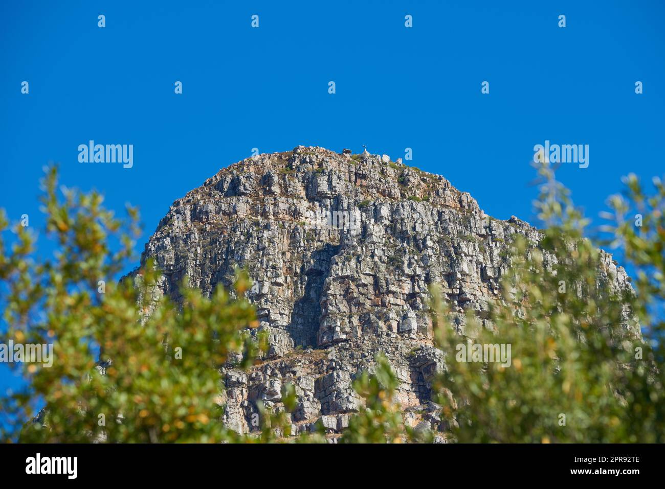 Vista panoramica della montagna, dello spazio copiato e dello sfondo blu del cielo dal lussureggiante giardino botanico verde o dal parco nazionale. Angolo basso di terreno accidentato, roccioso o pericoloso in località remote all'estero o all'estero Foto Stock