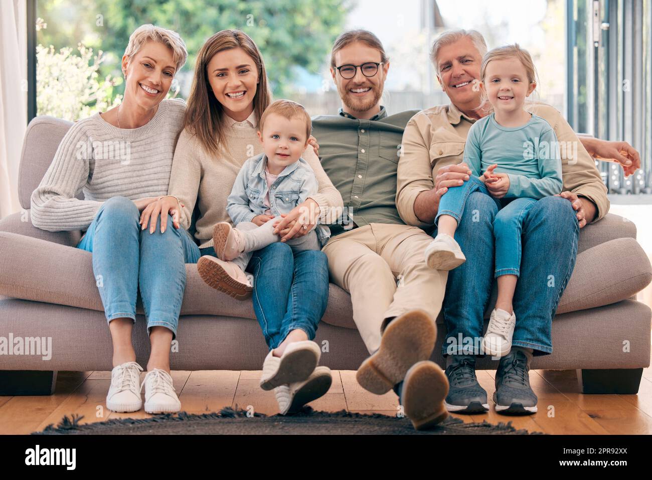 Più forti sono i legami, più felice è la casa. Una famiglia felice si rilassa sul divano di casa. Foto Stock