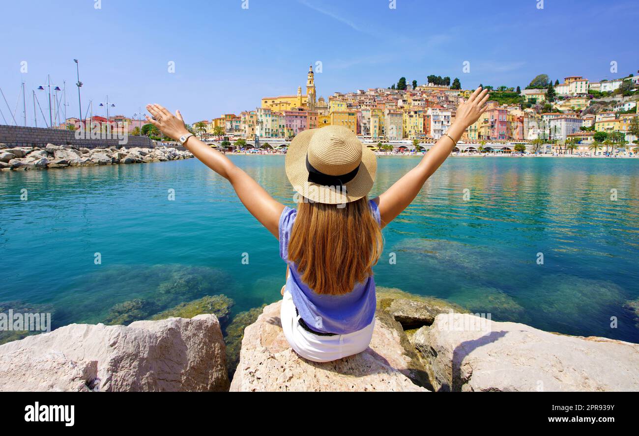 Viaggiare in Francia. Vista panoramica della ragazza viaggiatore con le braccia sollevate godendo la vista del villaggio di Menton, Costa Azzurra. Foto Stock