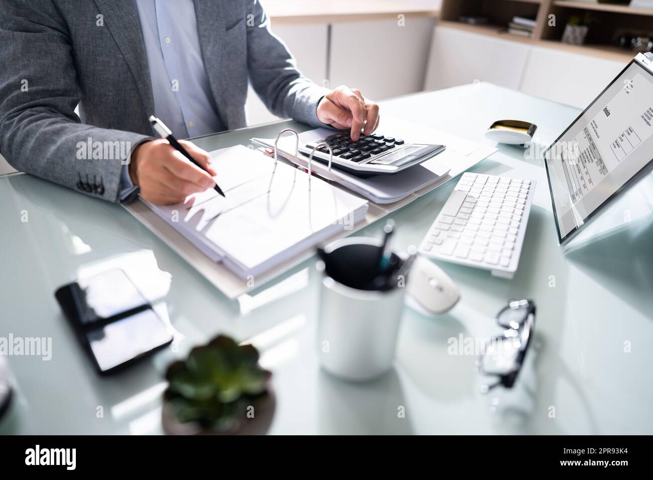 La mano di un uomo d'affari che calcola Bill in ufficio Foto Stock
